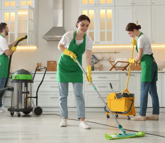 Team cleaning a bright kitchen
